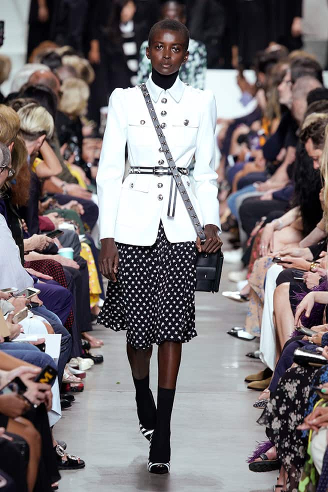 LOOK 58 - WHITE COTTON TWILL MILITARY JACKET, BLACK VISCOSE TURTLENECK DICKEY, BLACK/WHITE STAR CREPE DE CHINE PLEATED SKIRT, UTILITY MESSENGER