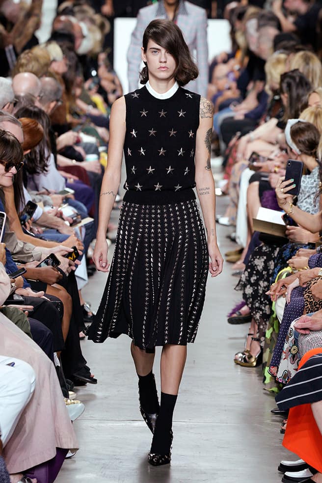 LOOK 63 - BLACK/SILVER STAR EMBROIDERED CASHMERE VEST, WHITE POPLIN DICKEY, BLACK WOOL SERGE PLEATED SKIRT WITH SILVER STAR EMBROIDERY